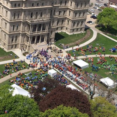 An aerial view of a large group of people gathered in front of a building.