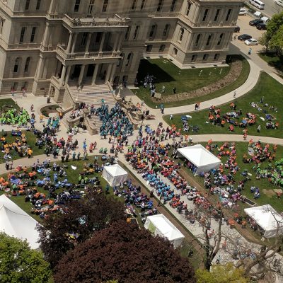 An aerial view of a group of people gathered in front of a building.