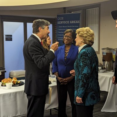 A group of people standing around a table with food.